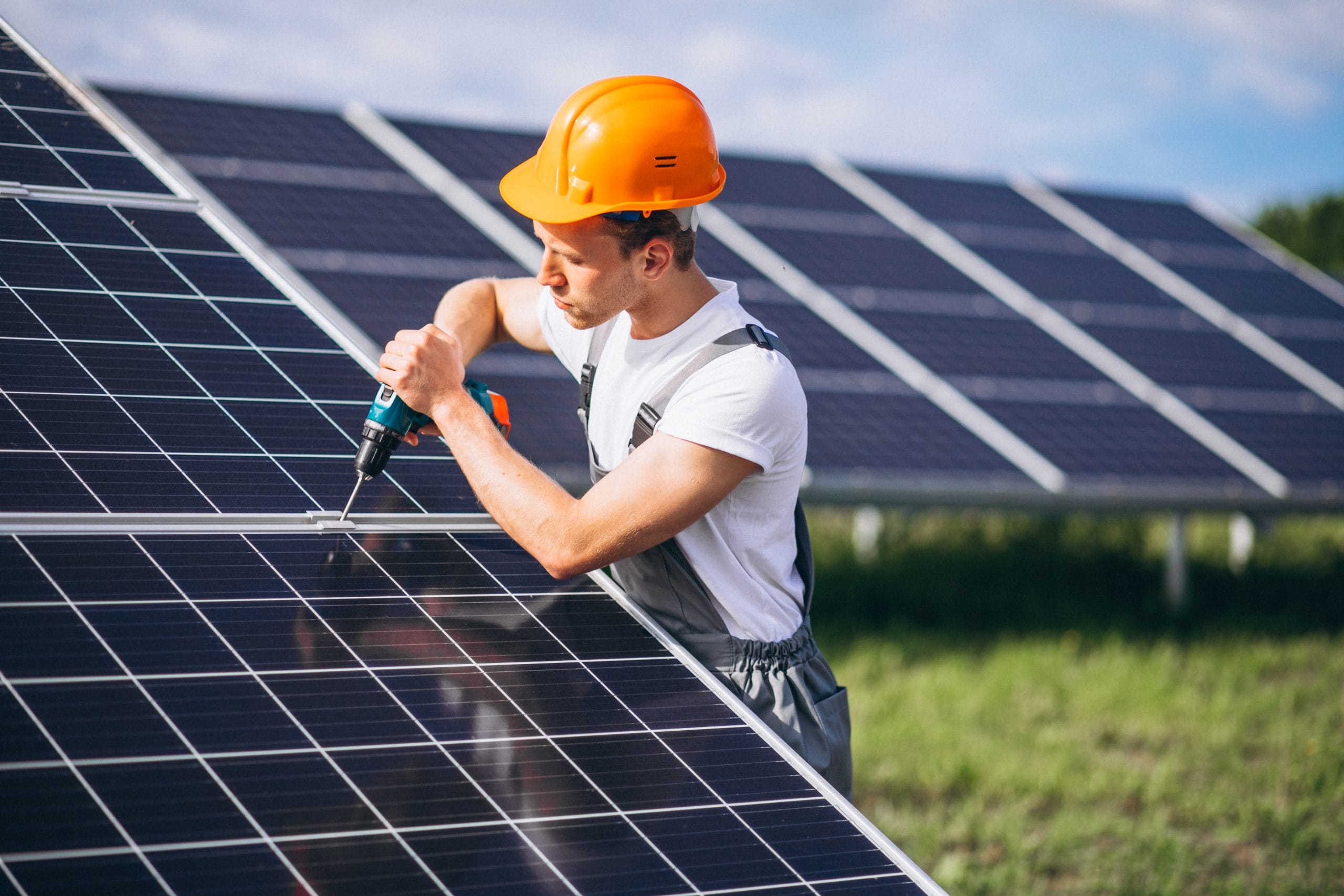 A worker in the field installing the solar panels